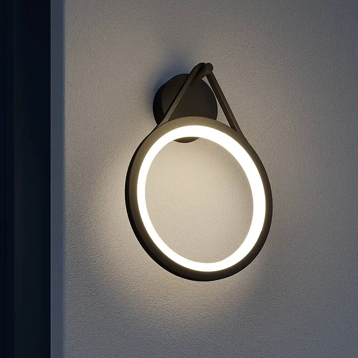 Lucande LED Wandleuchte aussen in anthrazit, weiß, Aussenlampe Wand -  - Moderne, dunkle Metall-LED-Wandleuchte in Ringform an einer strukturierten Wand, die ein warmes Licht abgibt.