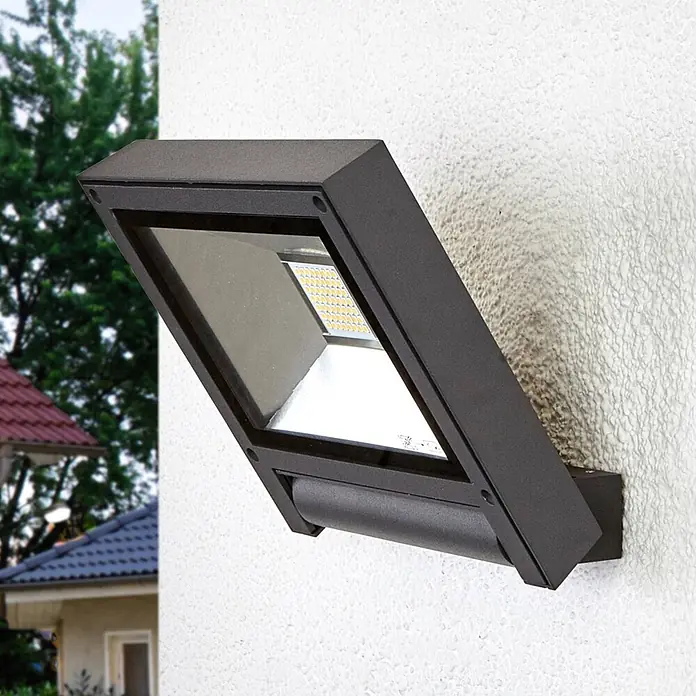 Lucande LED Wandleuchte innen in anthrazit, Wandstrahler -  - Schräge schwarze LED-Wandleuchte an strukturierter weißer Außenwand, mit heller Anordnung warmweißer LEDs.