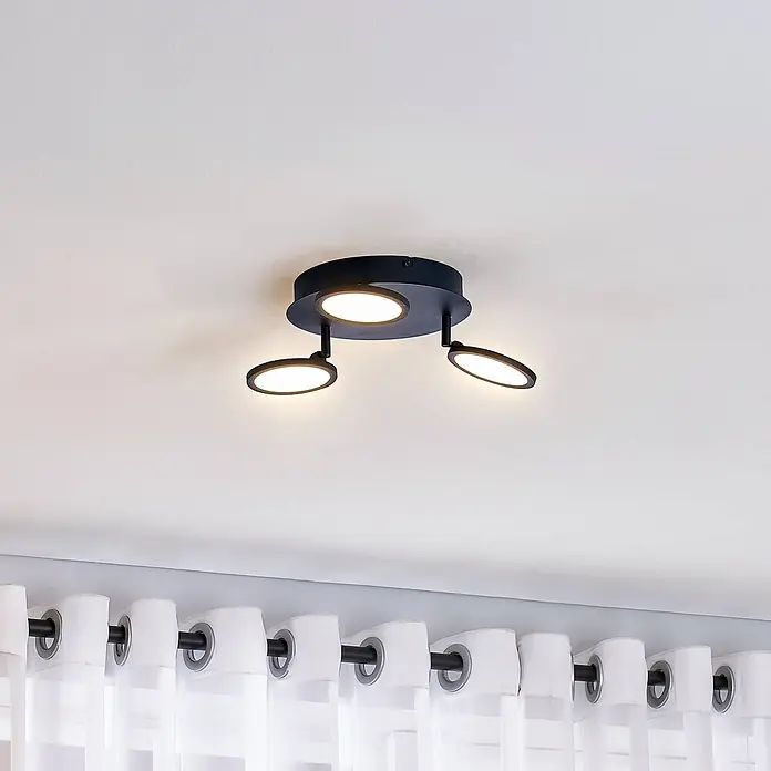 Lindby Deckenleuchte Manel - schwarz, schwarz - Schwarze Deckenleuchte mit drei verstellbaren, runden LED-Strahlern, montiert über Vorhängen.
