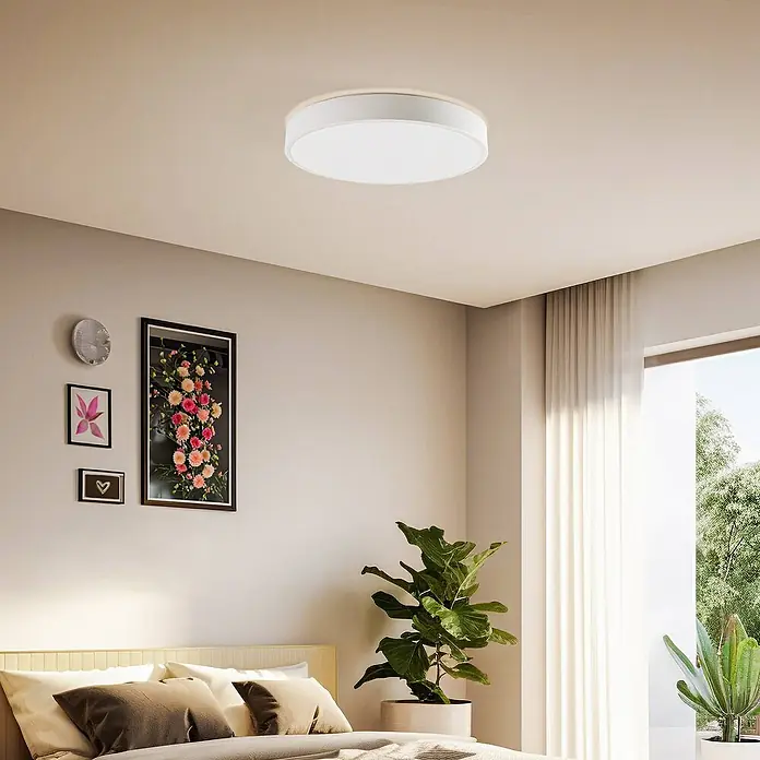 Lindby LED Deckenlampe Smart Home in weiß, dimmbar Deckenleuchte rund -  - Runde weiße Deckenleuchte mit hellem Rand, an einer Schlafzimmerdecke montiert.