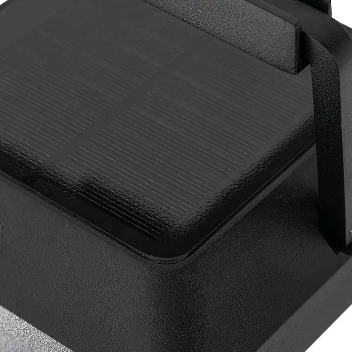 Lucande Außenwandleuchte Tilena - schwarz, IP54 - Nahaufnahme eines schwarzen, texturierten Solarpanels, das in ein dunkles Gehäuse integriert ist.