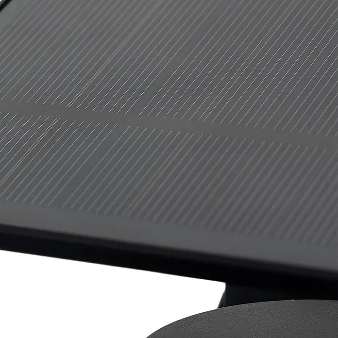 Lindby Außenwandleuchte Naelin - schwarz, schwarz, IP44 - Nahaufnahme eines dunkelgrauen Solarmoduls mit dünnen, parallelen Diagonalstreifen.