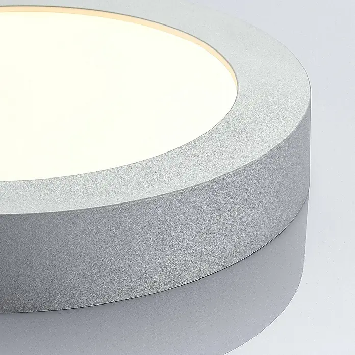 Arcchio LED Deckenlampe in silber, weiß, Deckenleuchte rund -  - Nahaufnahme einer beleuchteten runden silbernen LED-Deckenleuchte mit mattweißer Abdeckung.