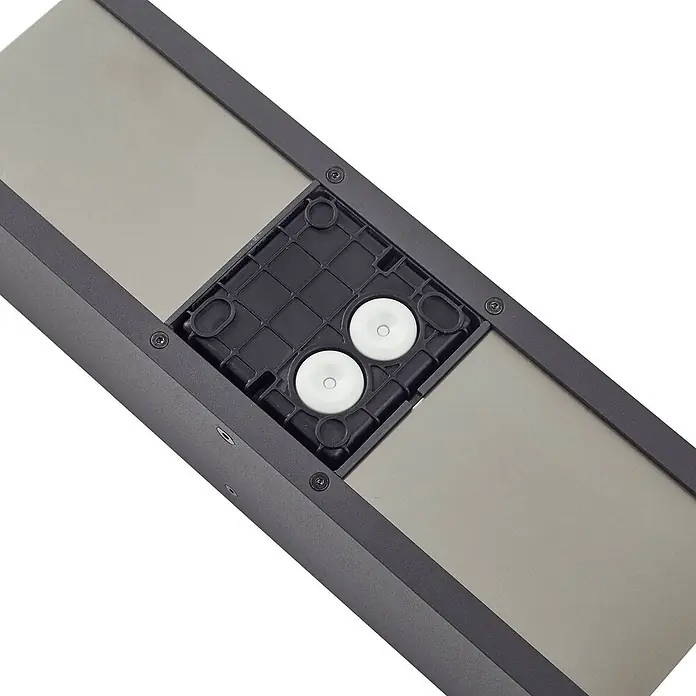 Lucande Außenwandleuchte Lavrin - schwarz, schwarz, IP54 - Dunkelgraues Rechteckteil mit metallischer Oberfläche und schwarzem Kunststoffmittelteil mit zwei weißen Libellen.