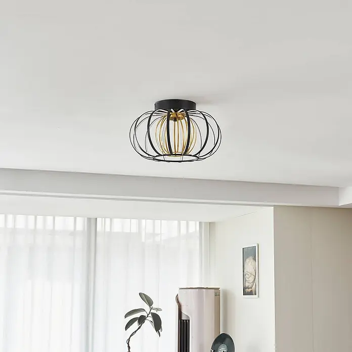 Lucande LED Deckenlampe in schwarz, gold, dimmbar Deckenleuchte rund -  - Eine schwarze und goldene Deckenleuchte mit offenem Käfigdesign, an einer weißen Decke in einem modernen Raum installiert.