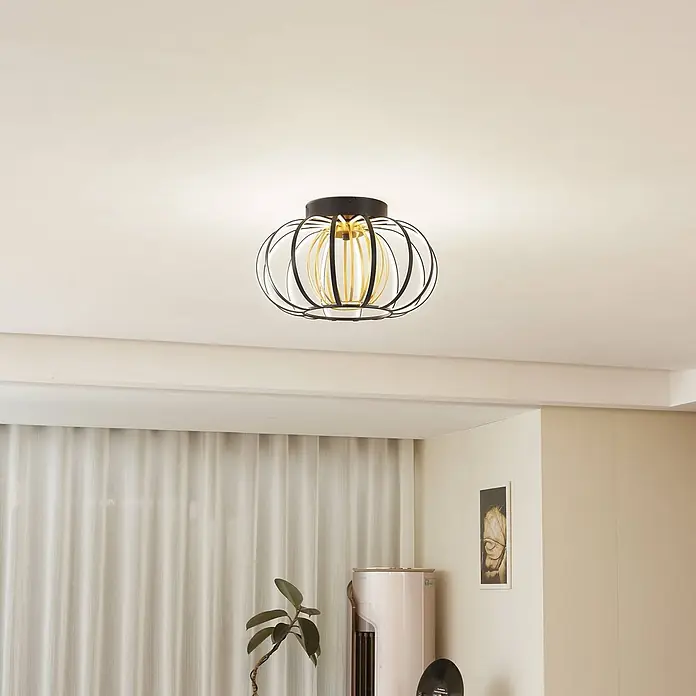 Lucande LED Deckenlampe in schwarz, gold, dimmbar Deckenleuchte rund -  - Eine dekorative schwarz-goldene Laternen-Deckenleuchte mit weißem Diffusor beleuchtet einen modernen Raum.