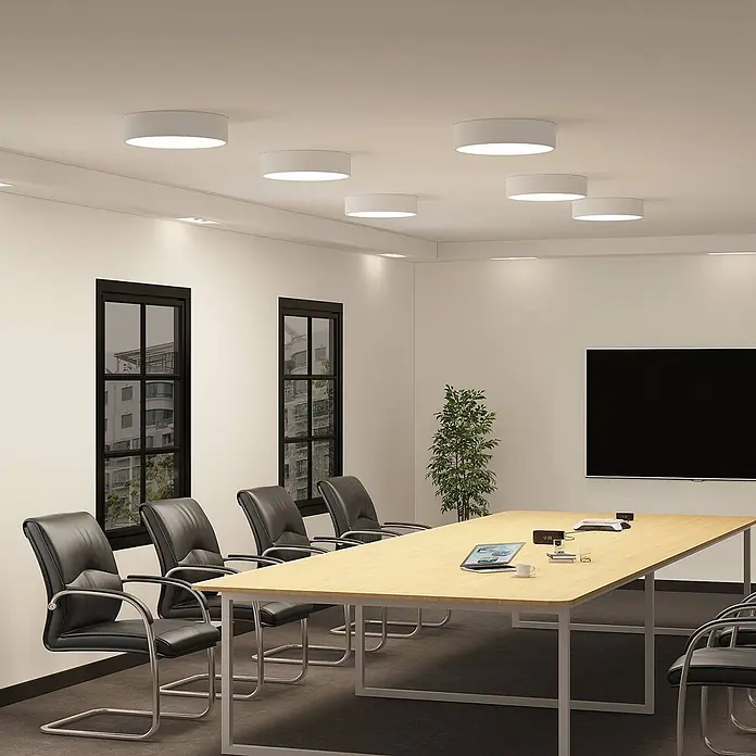 Arcchio LED Deckenlampe in weiß, Deckenleuchte rund -  - Mehrere weiße, zylinderförmige Deckenleuchten beleuchten einen modernen Konferenzraum mit langem Tisch und schwarzen Stühlen.