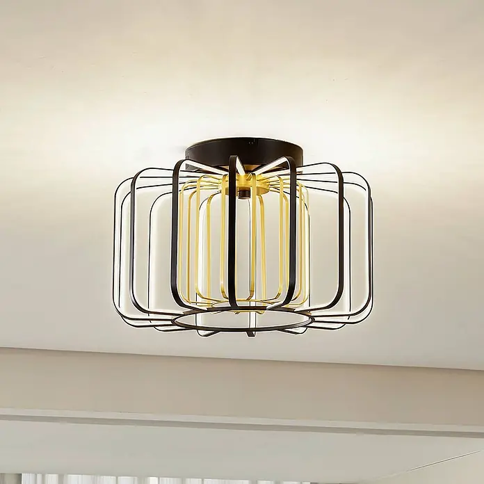 Lucande Deckenleuchte Birger - schwarz - Geometrische Deckenleuchte mit schwarzen und goldenen Metallrahmen um weiße Diffusoren, die einen Raum beleuchtet.