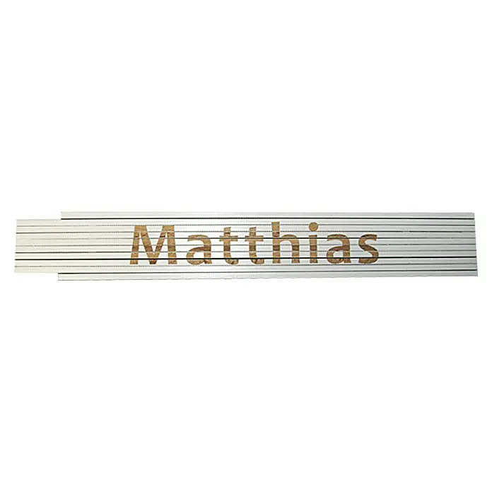 Zollstock - Aufdruck: Matthias, 2 m - Das Bild zeigt einen Zollstock mit dem Namen "Matthias" in brauner Schrift. Der Zollstock ist weiß mit feinen, horizontalen Linien.