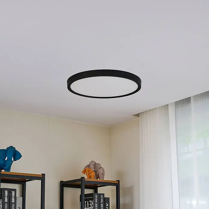 Lindby LED Deckenlampe in schwarz matt, weiß, Deckenleuchte rund -  - Eine runde, schwarze Deckenleuchte mit weißem Diffusor, bündig an einer weißen Decke in einem Raum montiert.