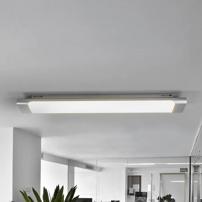Arcchio LED Deckenlampe in weiß, silber, Deckenleuchte -  - Eine lange, rechteckige, silberne LED-Deckenleuchte beleuchtet ein Büro.
