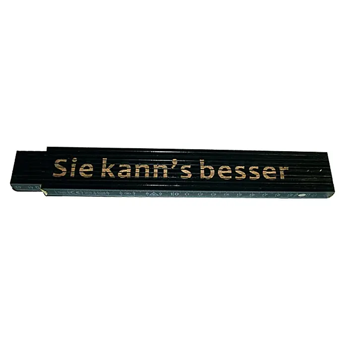 Zollstock - Aufdruck: Sie kann's besser, 2 m - Das Bild zeigt einen Zollstock aus Holz, mit der Aufschrift "Sie kann's besser" in goldenen Buchstaben. Ein praktisches Werkzeug.