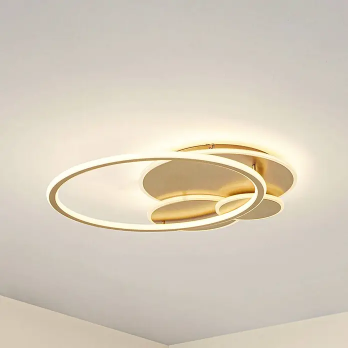 Lucande LED Deckenlampe in gold, Deckenleuchte rund -  - Moderne goldene LED-Deckenleuchte mit ineinander verschlungenen beleuchteten Ringen an einer hellen Decke.