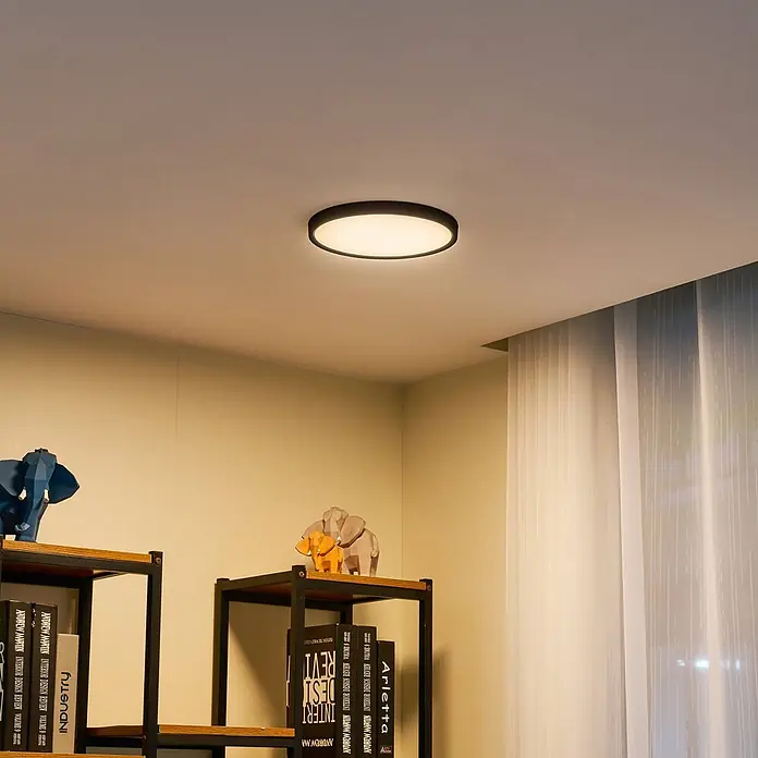 Lindby LED Deckenlampe Smart Home in schwarz matt, weiß, dimmbar -  - Schwarz umrandete, beleuchtete runde Deckenleuchte in einem modernen Raum, spendet warmes Umgebungslicht.