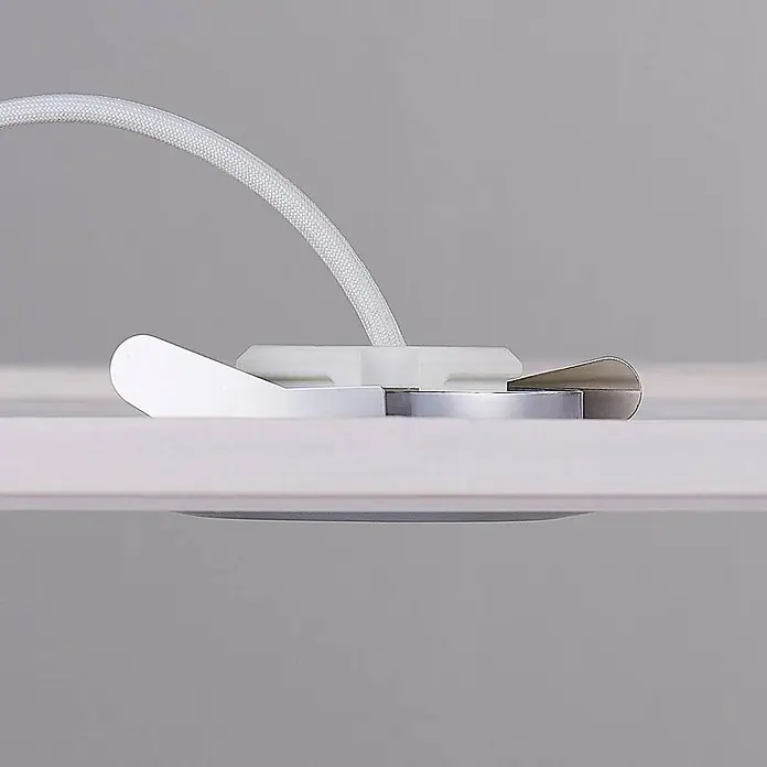 Lindby Deckenstrahler Andrej - alu / grau / zink, alu / grau / zink - Weißes geflochtenes Kabel, befestigt mit einer weißen Kunststoffklemme und einem silbernen Metallelement auf heller Oberfläche.