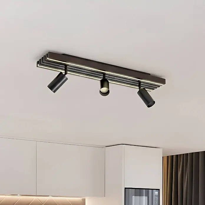 Lucande Deckenstrahler Tiron - Holz dunkel, schwarz - Dunkle Deckenleuchte mit drei verstellbaren zylindrischen Strahlern über einem modernen Küchenbereich.