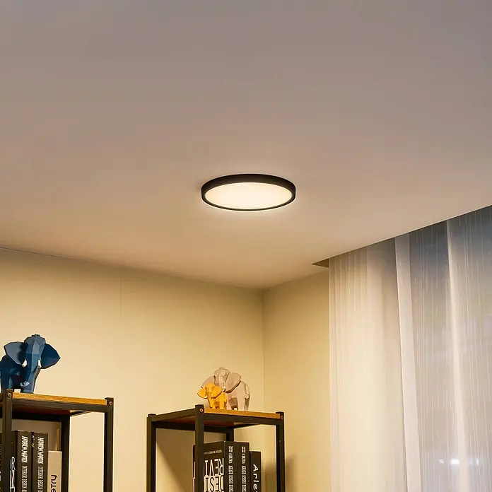 Lindby LED Deckenlampe in schwarz matt, weiß, Deckenleuchte rund -  - Runde, flache Deckenleuchte mit schwarzem Rahmen, beleuchtet einen Raum und spendet warmes Umgebungslicht.
