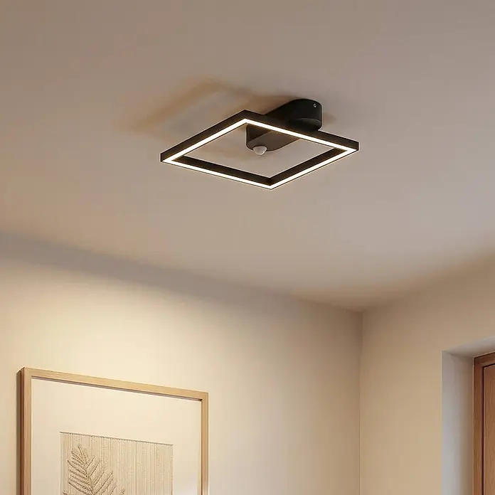 Lindby LED Deckenlampe in schwarz, Deckenleuchte -  - Schwarze quadratische LED-Deckenleuchte mit Bewegungsmelder, an heller Decke montiert, beleuchtet den Raum.