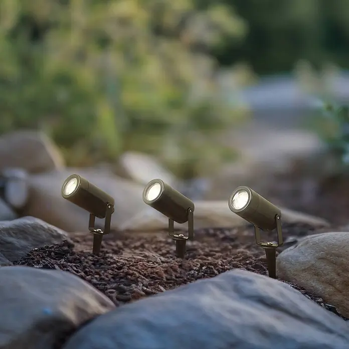 Lindby Gartenstrahler mit Erdspieß in schwarz, Strahler Garten -  - Drei dunkelmetallische Outdoor-Strahler mit hellen LEDs, im Gartenboden zwischen Steinen verankert. Ideal zur Weg- oder Landschaftsbeleuchtung.