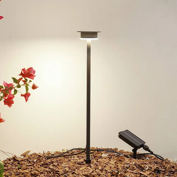Lindby LED Solar Gartenlampe Erdspieß in schwarz matt, Erdspießlampe -  - Dunkelgraue solarbetriebene LED-Wegeleuchte für den Außenbereich mit separatem Solarpanel, im Garten installiert.