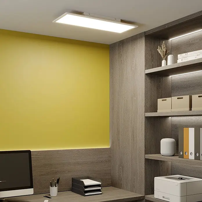 Lindby LED-Panel Luay - weiß / opal, weiß / opal - Rechteckige weiße Deckenleuchte, die ein modernes Büro mit gelber Akzentwand und Holzregalen beleuchtet.