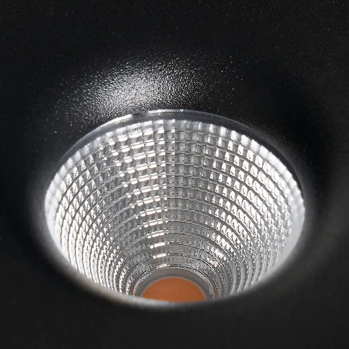 Arcchio LED Deckenlampe in schwarz, Deckenleuchte rund -  - Nahaufnahme eines schwarzen LED-Einbaustrahlers mit strukturiertem silbernem Reflektor, der sich zu einer orangefarbenen Lichtquelle verjüngt.