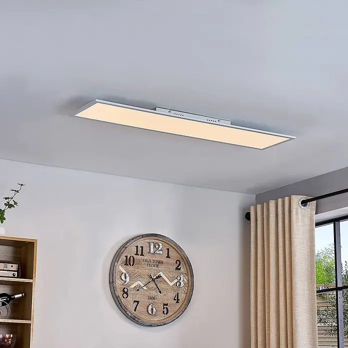 Lindby LED-Panel Lamin - weiß / opal - Rechteckige LED-Deckenleuchte mit silbernem Rahmen, an der Decke montiert, beleuchtet ein Wohnzimmer.