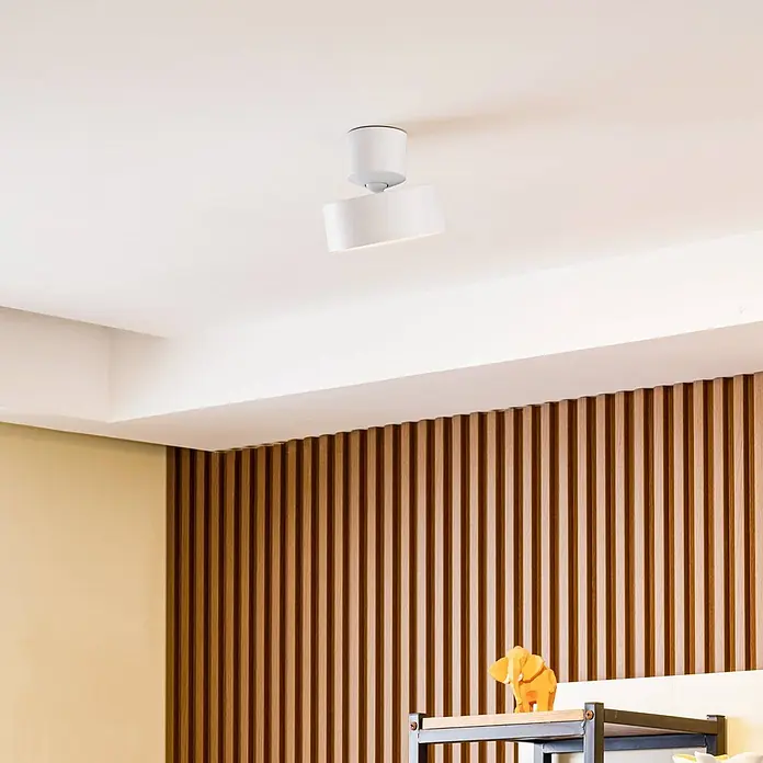 Lindby LED Deckenlampe in weiß, Deckenstrahler -  - Weiße verstellbare Deckenleuchte, die einen Raum mit Holzlamellenwand beleuchtet.