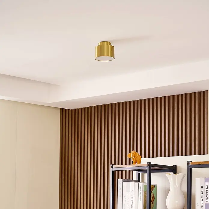 Lindby LED Aufbauleuchte gold Ø 11 cm, Aufbaustrahler, Deckenspot 15W LED -  - Goldene zylindrische Deckenleuchte in einem modernen Raum.