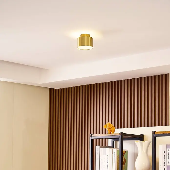 Lindby LED Aufbauleuchte gold Ø 11 cm, Aufbaustrahler, Deckenspot 15W LED -  - Goldene zylindrische Deckenleuchte beleuchtet einen Raum.