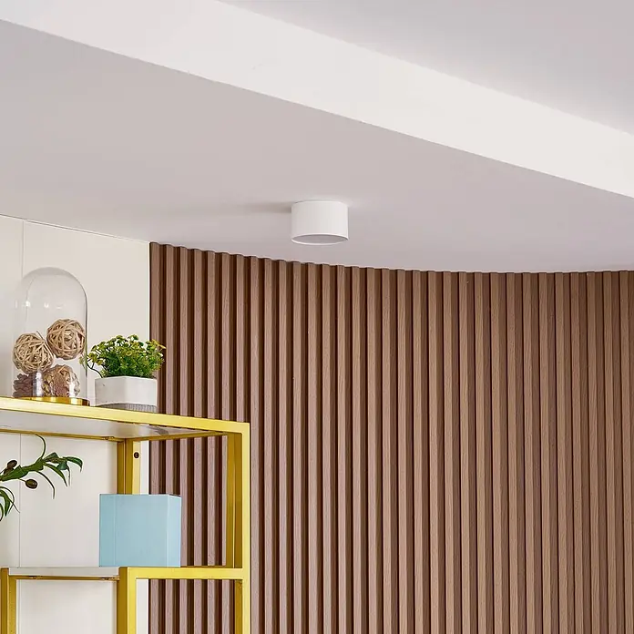 Lindby LED Aufbauleuchte weiß Ø 11 cm, Aufbaustrahler, Deckenspot 9W LED -  - Weiße zylindrische Deckenleuchte auf einer weißen Decke in einem modernen Raum mit Holzlamellenwand.