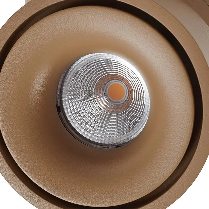 Arcchio LED Deckenlampe in braun, Deckenstrahler -  - Nahaufnahme eines braunen LED-Strahlers mit strukturiertem Silberreflektor und warmem orangefarbenem Leuchtkern.