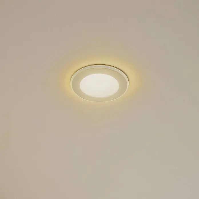 Lindby Einbauleuchte Toka - weiß / opal - Weiße runde LED-Deckenleuchte spendet warmes Licht an einer cremefarbenen Decke.