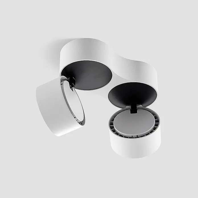 Arcchio LED Deckenlampe in weiß, Deckenstrahler -  - Weißer, zweiköpfiger, verstellbarer Deckenstrahler mit schwarzen Innenaussparungen, ein Kopf nach unten geneigt, der eine graue Lichtquelle zeigt.