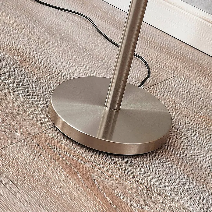 Lindby Stehlampe / Deckenfluter Metall Glas, Standleuchte Nickel satiniert -  - Gebürsteter Metall-Stehlampenfuß mit zylindrischem Ständer und schwarzem Kabel auf hellem Holzfußboden.