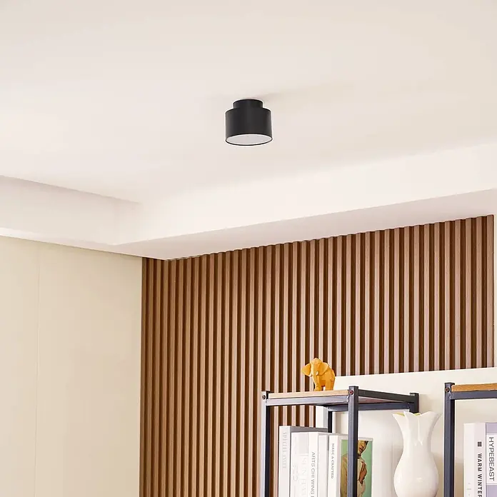 Lindby Deckenstrahler Nivoria - schwarz - Schwarze zylindrische Deckenleuchte an einer weißen Decke montiert.