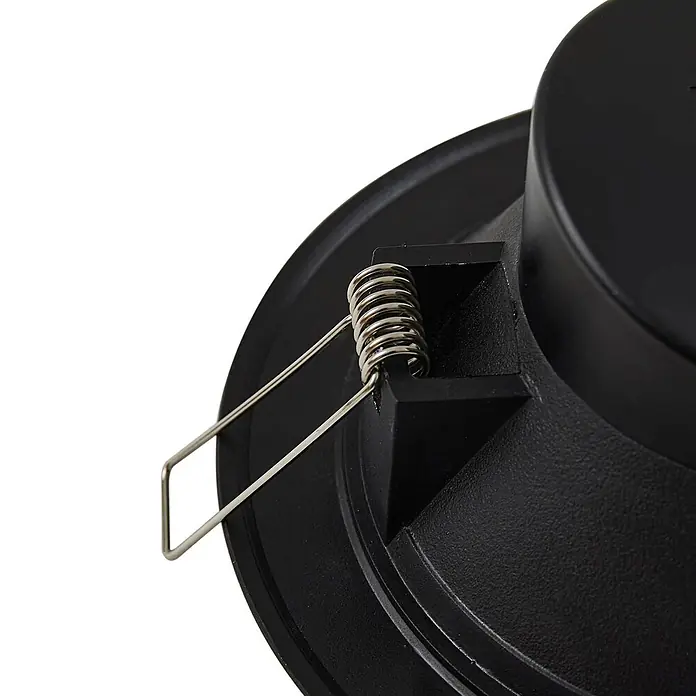 Prios Einbauleuchte - schwarz - Nahaufnahme einer schwarzen runden Halterung mit einem markanten silbernen Federclip-Mechanismus zur sicheren Befestigung.