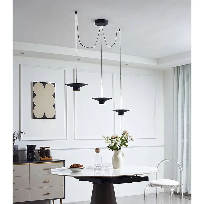 Lindby LED Pendelleuchte in schwarz, dimmbar up down Hängelampe -  - Drei schwarze Pendelleuchten mit konischen Schirmen hängen elegant über einem weißen Esstisch in einem modernen Ambiente.