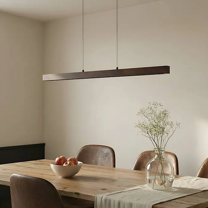 Lucande LED Pendelleuchte in walnuss, schwarz, dimmbar Hängelampe -  - Dunkelbraune lineare Pendelleuchte über einem Holzesstisch.