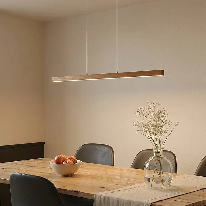 Lucande LED Pendelleuchte in holz, dimmbar Hängelampe -  - Lineare hölzerne Pendelleuchte mit integrierter LED-Leiste über einem Esstisch.