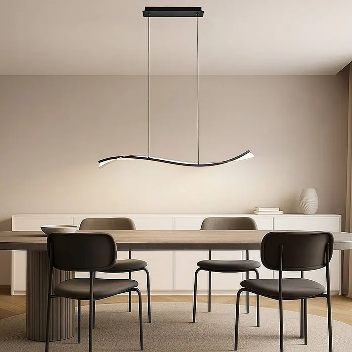 Lucande LED Pendelleuchte in blattgold, schwarz, Hängelampe -  - Moderne schwarze, wellenförmige LED-Pendelleuchte beleuchtet einen Esstisch mit dunklen Stühlen.
