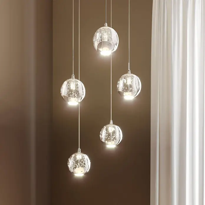 Lucande LED Pendelleuchte in transparent, chrom, Hängelampe -  - Fünf kugelförmige Pendelleuchten mit klaren, funkelnden Glasschirmen erhellen einen Raum.