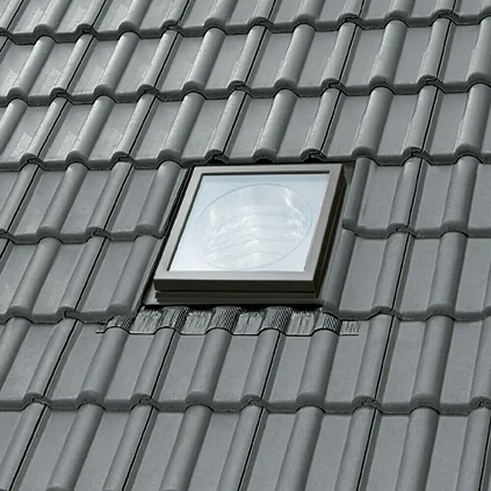 Velux Tageslicht-Spot TWR OK14 SDOW1 - Dachneigung: 15 ° - 60 ° - Ein Dachfenster ist in ein Ziegeldach integriert, das natürliches Licht hereinlässt und gleichzeitig die Wetterbeständigkeit des Daches erhält.