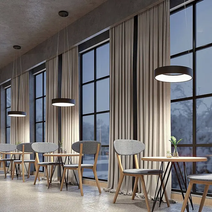 Arcchio LED Pendelleuchte in schwarz, weiß, Hängelampe -  - Modernes Café-Interieur mit runden Tischen, grauen Stühlen und runden Pendelleuchten, vor großen Fenstern mit Winterlandschaft.
