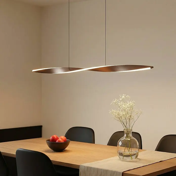 Lindby LED Pendelleuchte in braun, Hängelampe -  - Moderne braune verdrehte lineare Pendelleuchte beleuchtet einen Esstisch aus Holz.