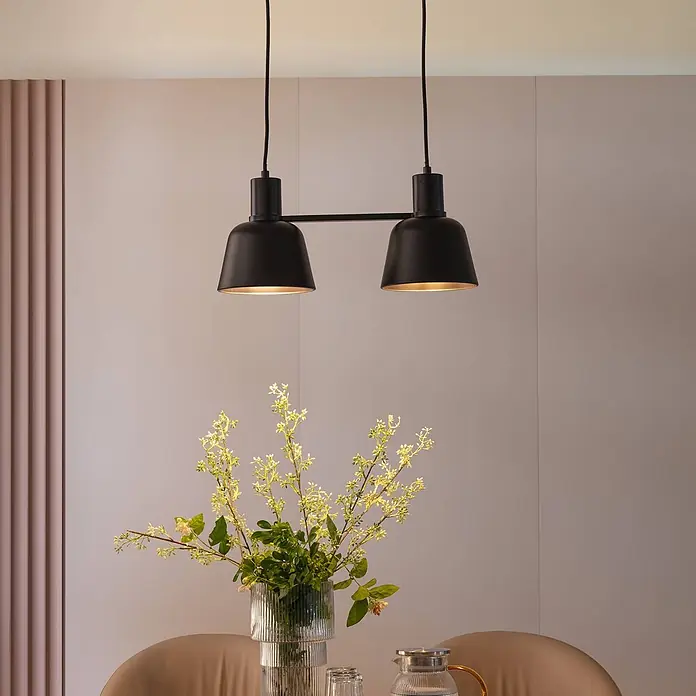 Lucande Pendelleuchte in schwarz matt, Hängelampe -  - Schwarze doppelte Pendelleuchte aus Metall hängt über einem Tisch und beleuchtet einen Essbereich.