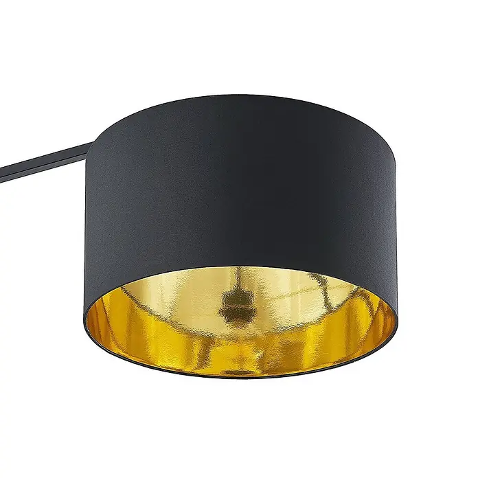 Arcchio Stehleuchte Mossa - schwarz, schwarz, E27 - Zylindrischer Lampenschirm, außen schwarz, innen gold. Ein Arm ragt von links hinein.