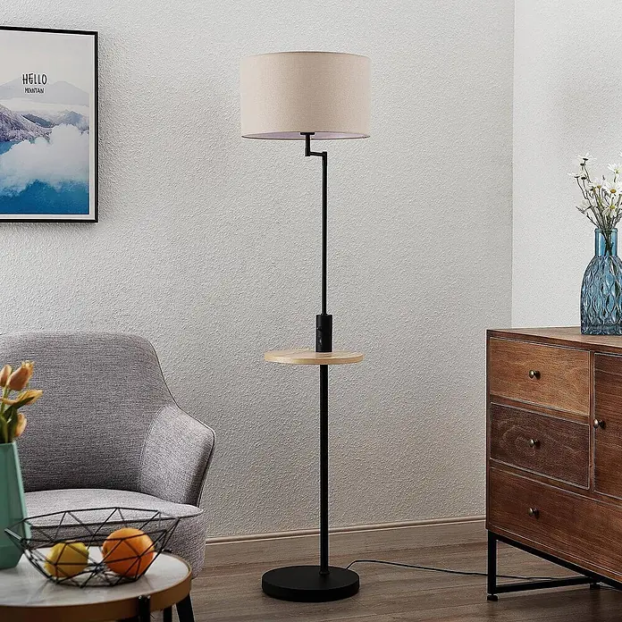 Lindby Stehlampe Wohnzimmer in schwarz matt, beige, Stehleuchte -  - Stehlampe mit beigem Schirm, schwarzem Ständer und runder Holzablage mit USB-Ladeanschluss, in einem Wohnzimmer.