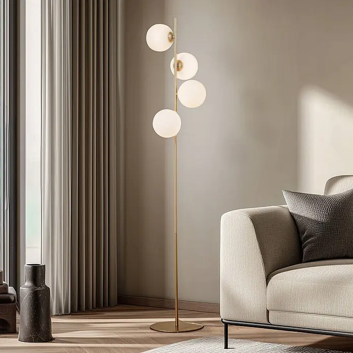 Lucande Stehlampe Wohnzimmer in gold matt, weiß, Stehleuchte -  - Eine goldene Stehlampe mit vier weißen kugelförmigen Lichtern, die ein modernes Wohnzimmer neben einem hellen Sofa beleuchtet.