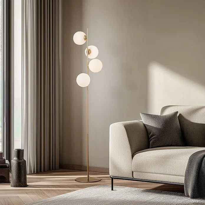 Lucande Stehlampe Wohnzimmer in gold matt, weiß, Stehleuchte -  - Goldfarbene Stehlampe mit vier kugelförmigen weißen Glasschirmen, die neben einem hellen Sofa warmes Licht spendet.